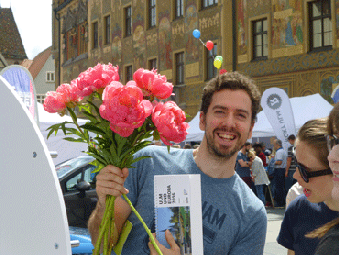 Ein Mann mit Blumenstrauß und unserem Europa-Kalender in der Hand