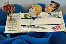 Gebasteltes Boot, auf dem die Porträts des amerikanischen und des brasilianischen Präsidenten zu sehen sind. Es trägt die Aufschrift "Platz 1 der meisten Todesfälle".